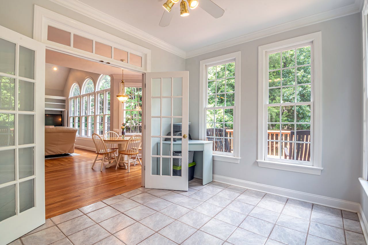 About Bright living area showcasing elegant French doors, dining set, and lush outdoor view.